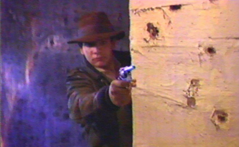 Chris Strompolos as Indiana Jones shoots from cover in the adaptation of Raiders of the Lost Ark in Drafthouse Films’ Raiders! Courtesy of Drafthouse Films.